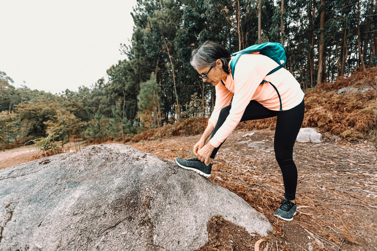 Woman tying her walking shoe on a hike